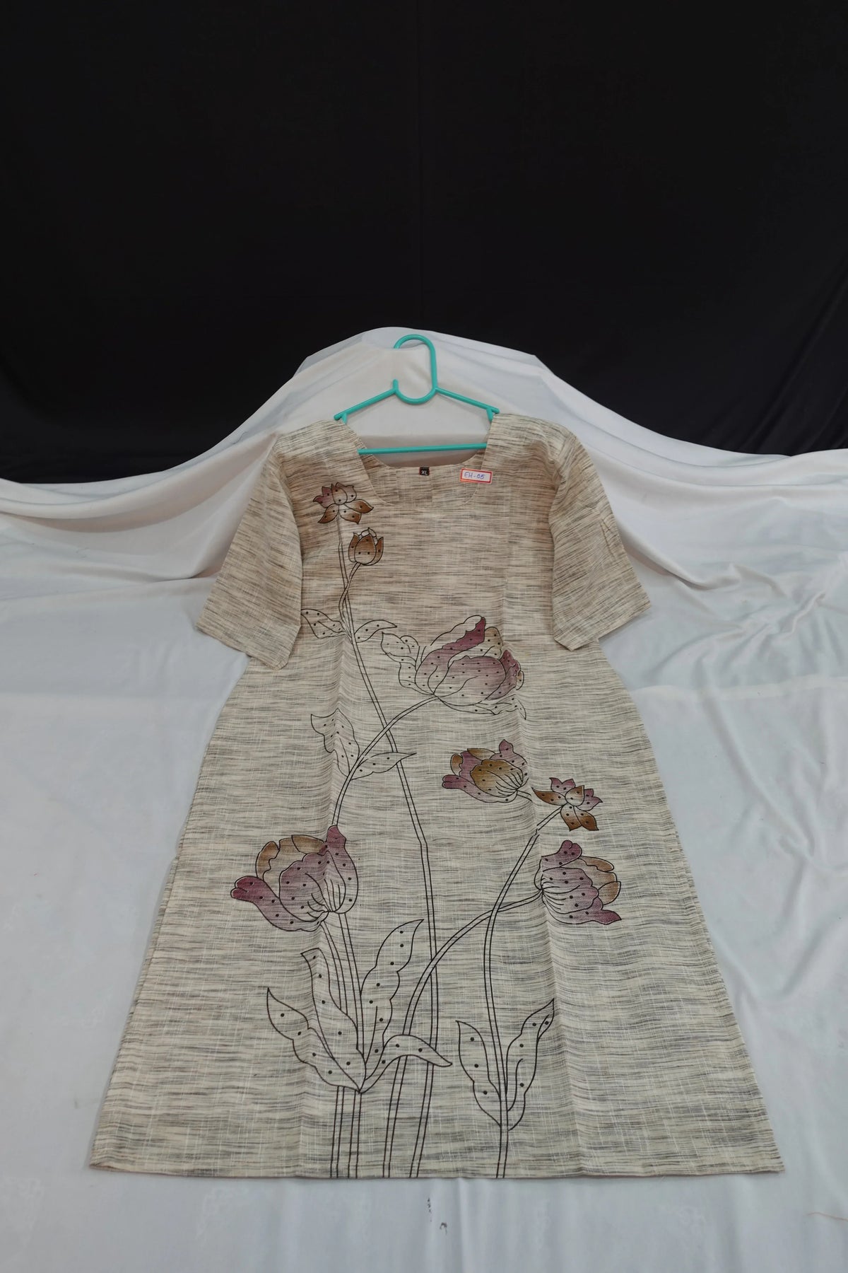 Floral dress with a hanger on a white background