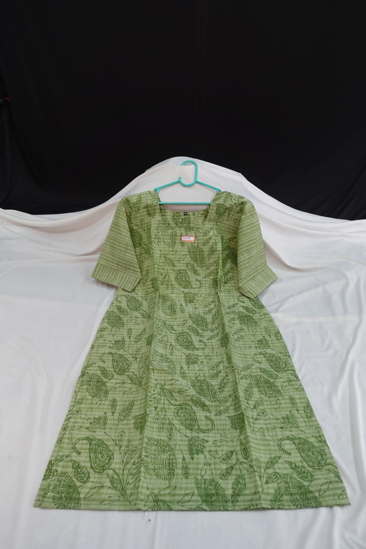 Green patterned dress on a white background