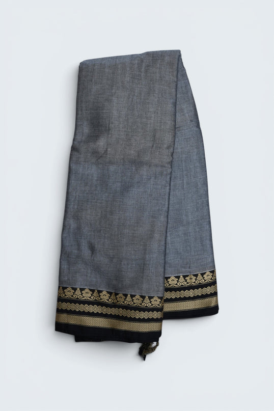 Bhavana Handlooms ash grey mercerized cotton saree with traditional woven black and gold border. Lightweight and soft finish.