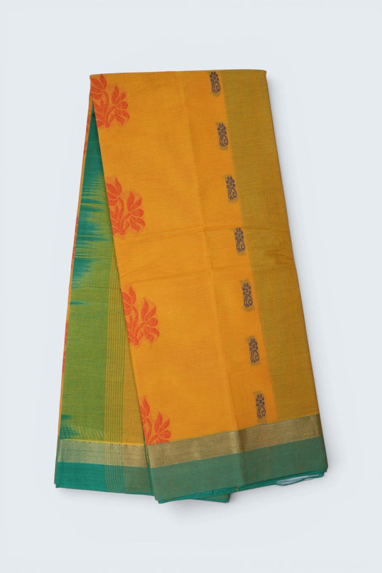 Bhavana Handlooms mustard yellow Coimbatore handloom saree featuring traditional floral butta motifs and green border.