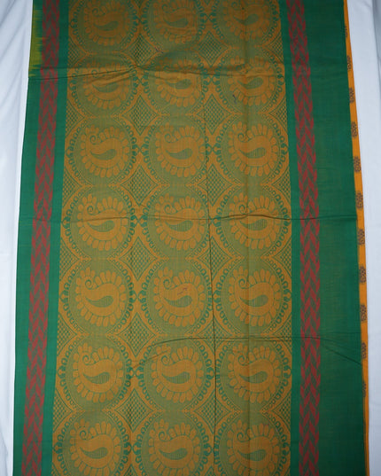 Bhavana Handlooms mustard yellow Coimbatore handloom saree featuring traditional green floral butta motifs and border.