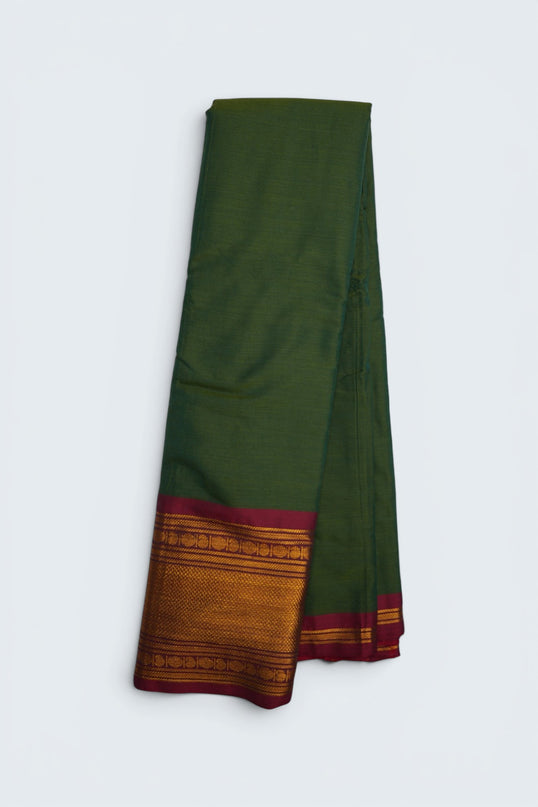 Bhavana Handlooms olive green mercerized cotton saree with rich zari border and maroon trim. Lightweight, soft finish.