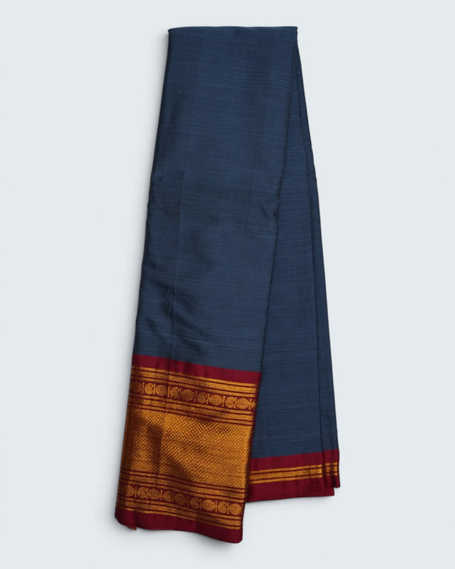 Bhavana Handlooms steel blue mercerized cotton saree with rich zari border and red trim. Lightweight and soft finish.
