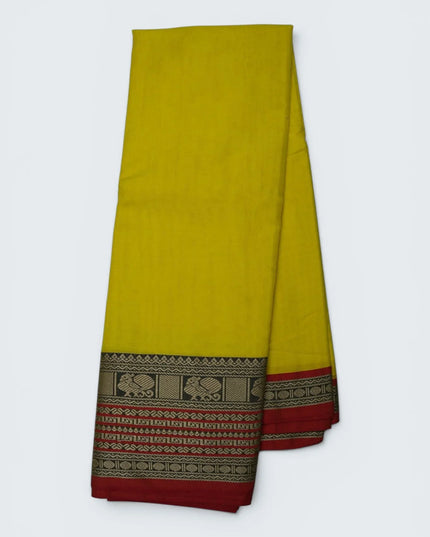 Bhavana Handlooms bright turmeric yellow mercerized cotton saree with traditional peacock zari border and red hem. Lightweight drape.